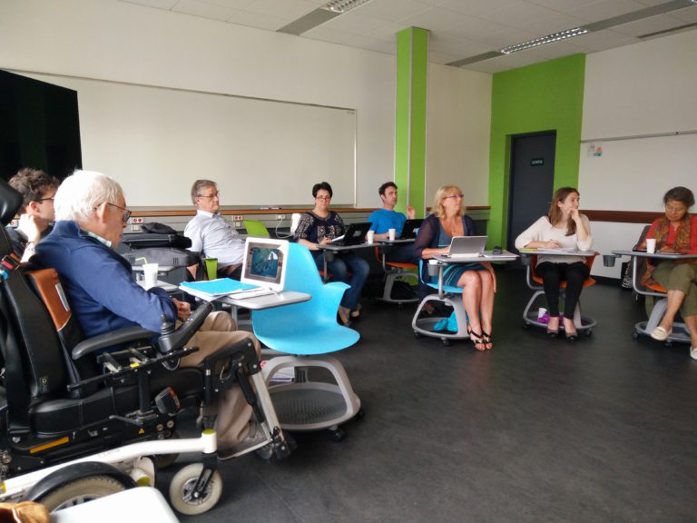 The participants are seated, while listening to the coordinator.